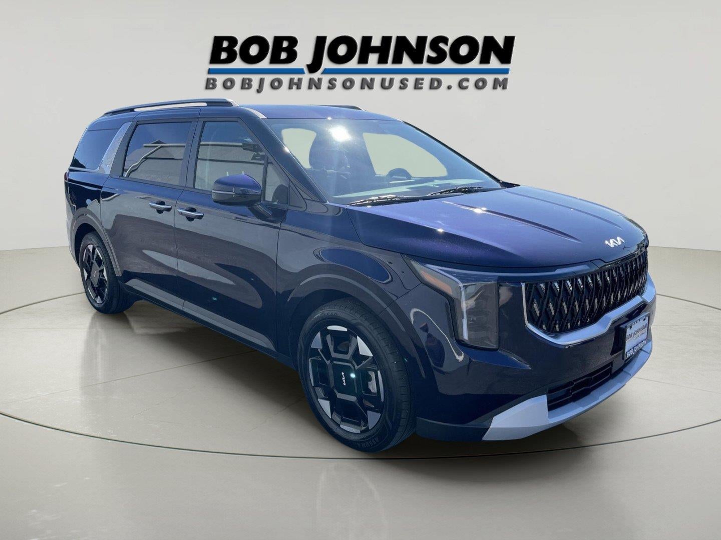 2026 Kia Carnival EX in Deep Chroma Blue — front three-quarter view
